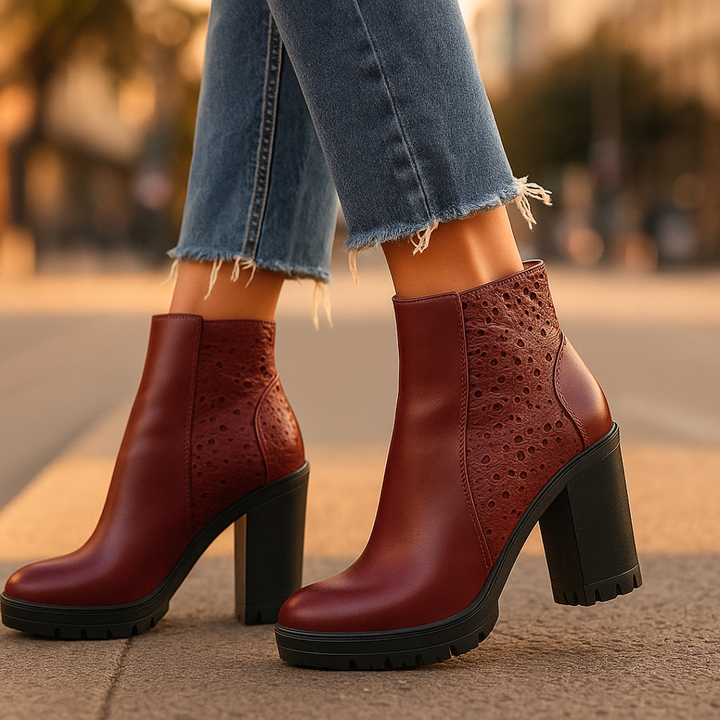 Red high-heeled boots worn with blue jeans on a blurred street background